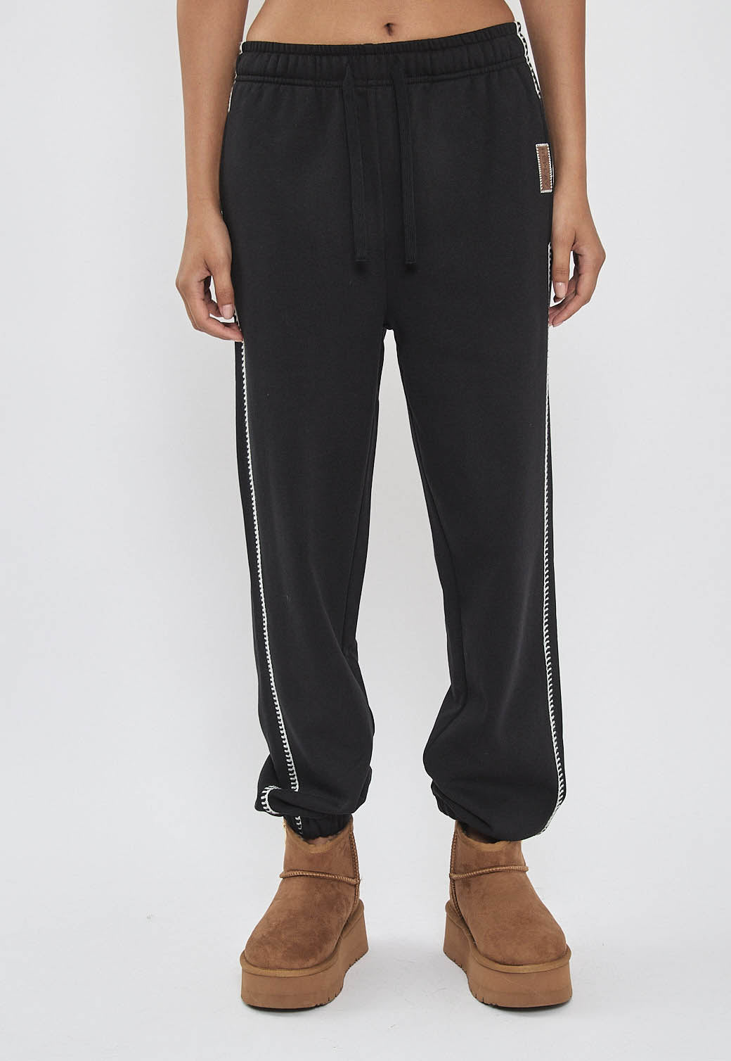 מכנסי טרנינג לנשים בצבע שחור עם פס צד ולוגו