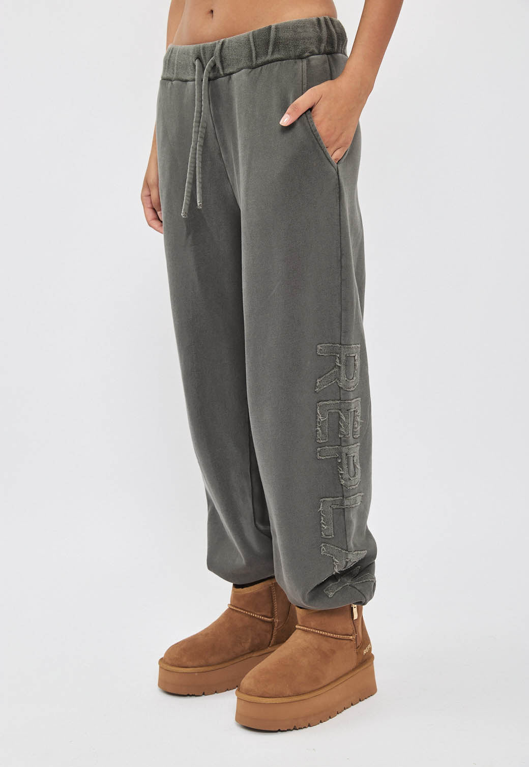 מכנסי טרנינג לנשים בצבע אפור כהה עם כיתוב לוגו בצד