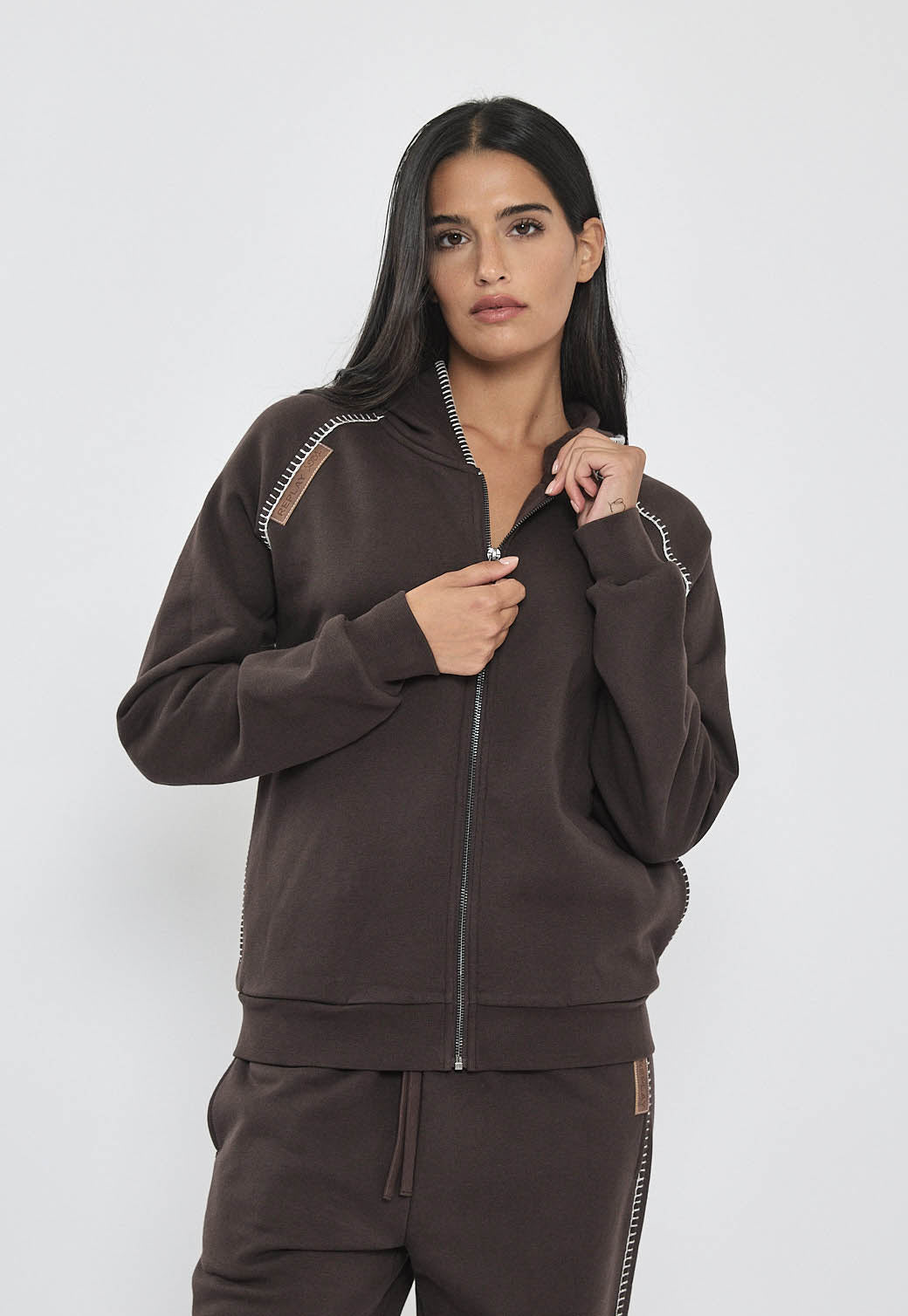 ג׳קט רוכסן לנשים בצבע חום כהה עם תפרי דקורציה בכתפיים, גזרה רגילה ומכפלים אלסטיים.