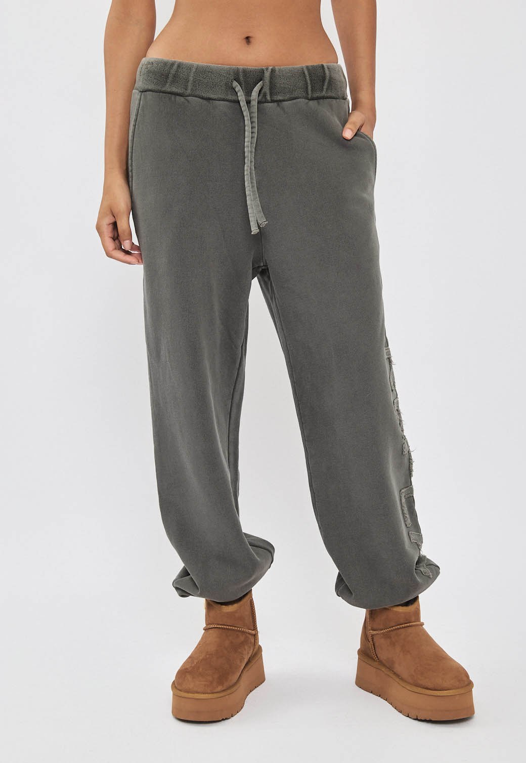 מכנסי טרנינג לנשים בצבע אפור כהה עם כיתוב לוגו בצד