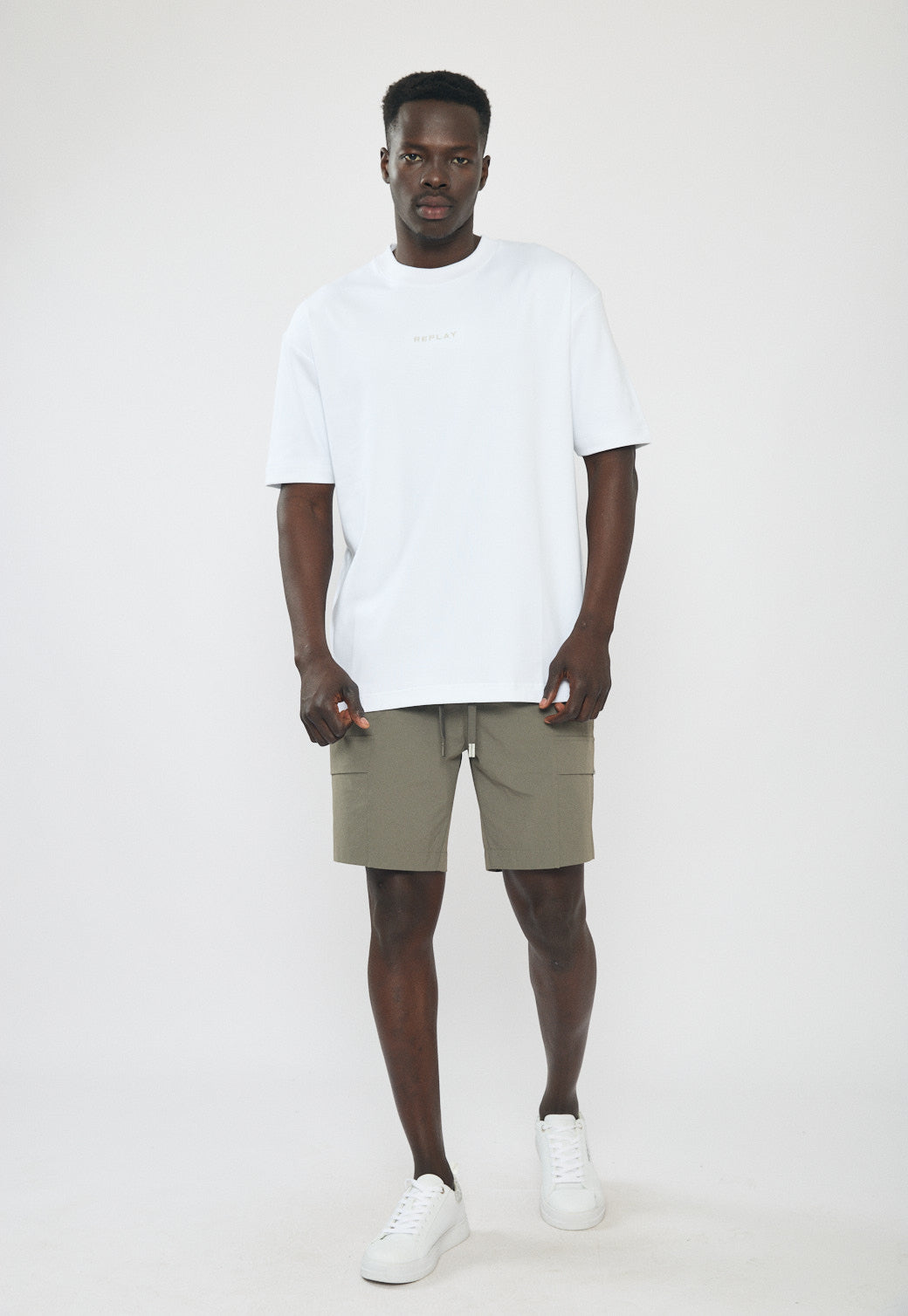 דוגמן לובש מכנסיים קצרים לגברים בצבע ירוק זית בסגנון קרגו עם כיסים ושרוך קשירה