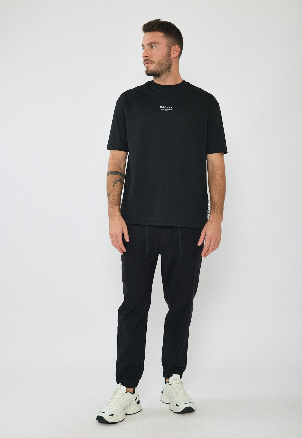 דוגמן לובש מכנסיים ארוכים לגברים בצבע שחור עם שרוך קשירה וסיומת מכווצת בקרסול