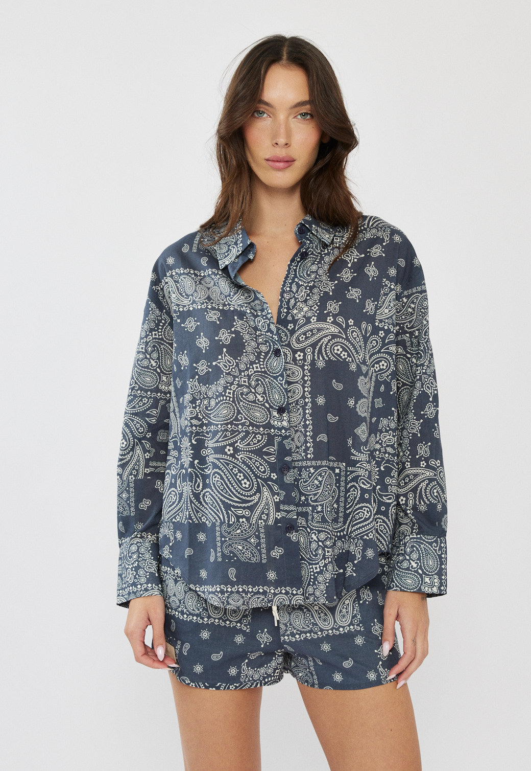 דוגמנית לובשת חולצה מכופתרת לנשים בצבע כחול עם הדפס פייזלי בגזרה רחבה